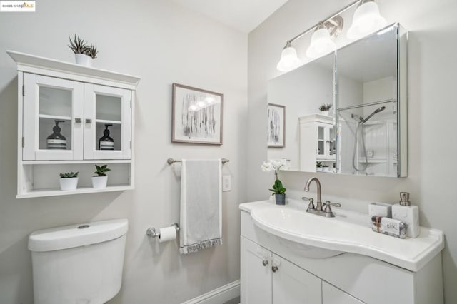 bathroom featuring vanity, walk in shower, and toilet