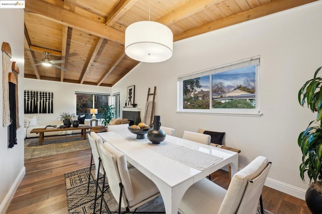 dining space featuring dark hardwood / wood-style flooring, a brick fireplace, wooden ceiling, and vaulted ceiling with beams