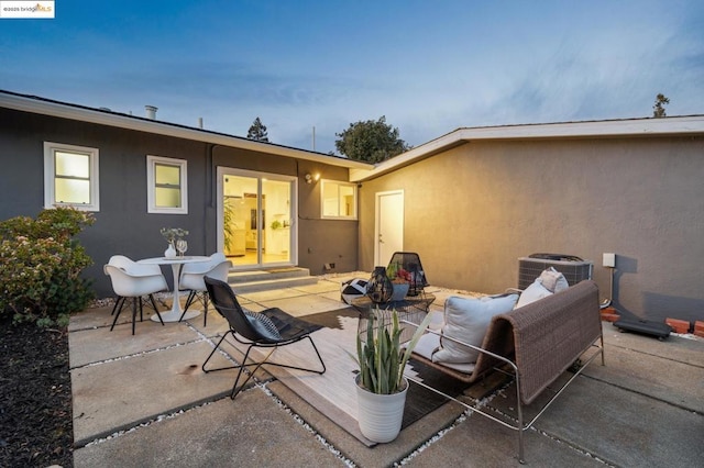 patio terrace at dusk featuring central AC