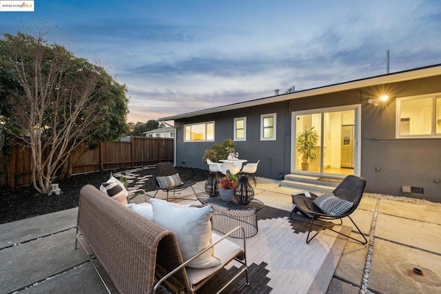 patio terrace at dusk featuring an outdoor hangout area