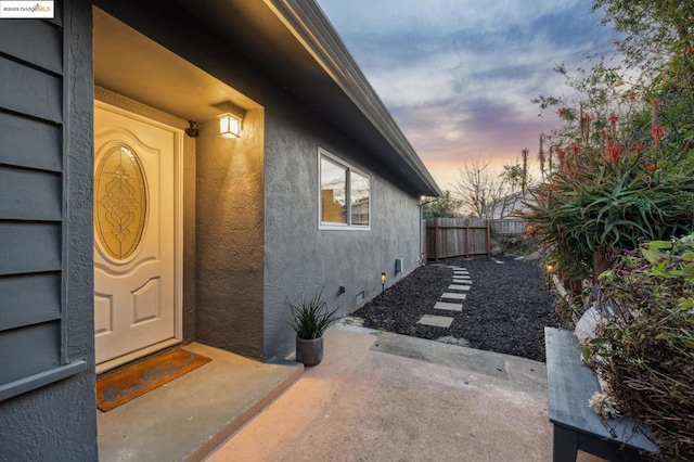 exterior entry at dusk with a patio area