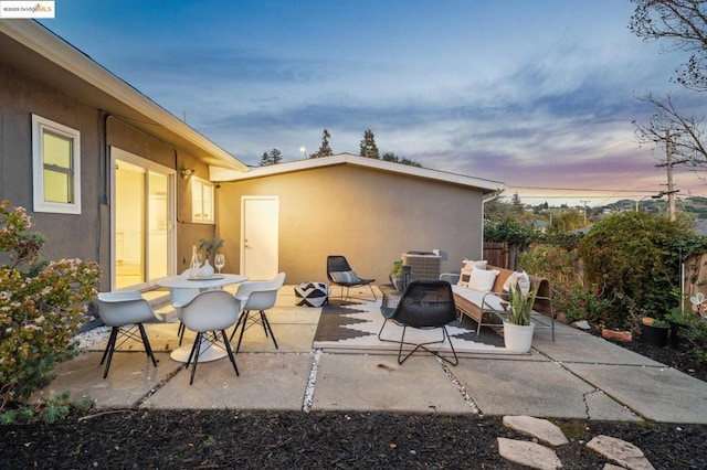 patio terrace at dusk with an outdoor hangout area and central AC