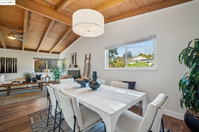 dining space featuring dark hardwood / wood-style flooring, vaulted ceiling with beams, wood ceiling, and a tile fireplace