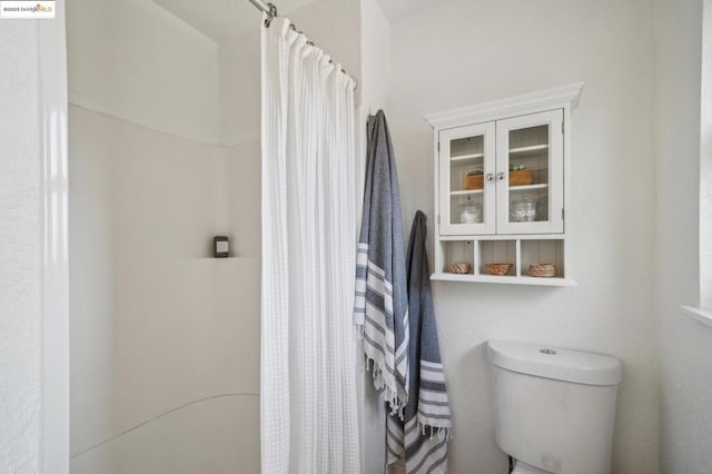 bathroom with toilet and curtained shower