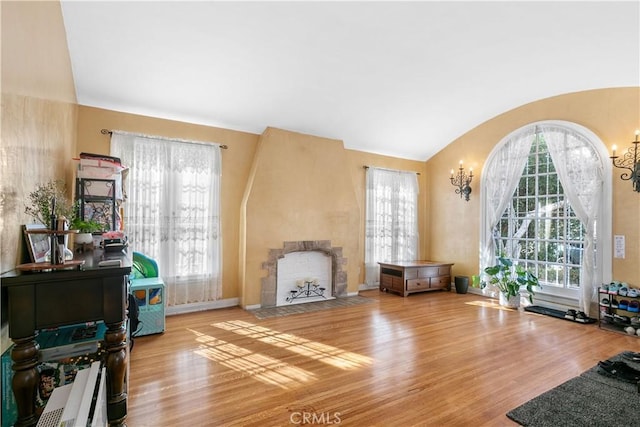 sitting room featuring vaulted ceiling, light hardwood / wood-style floors, and a chandelier