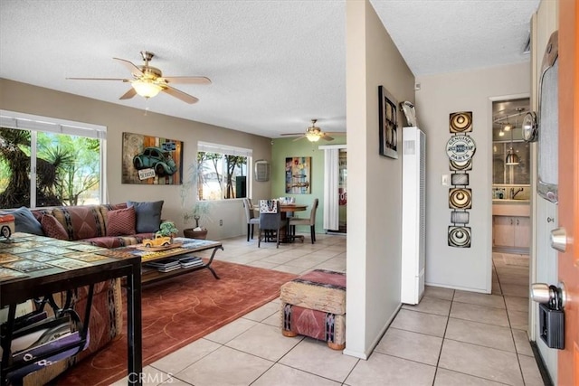 tiled living room featuring ceiling fan and a textured ceiling