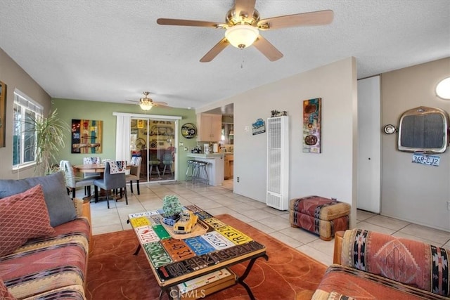 tiled living room featuring ceiling fan and a textured ceiling