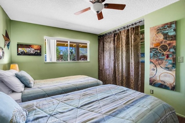 bedroom featuring ceiling fan and a textured ceiling