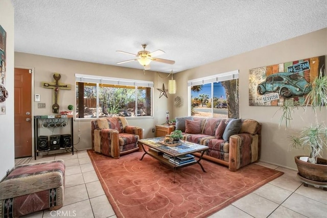 living room with ceiling fan, a textured ceiling, and light tile patterned floors