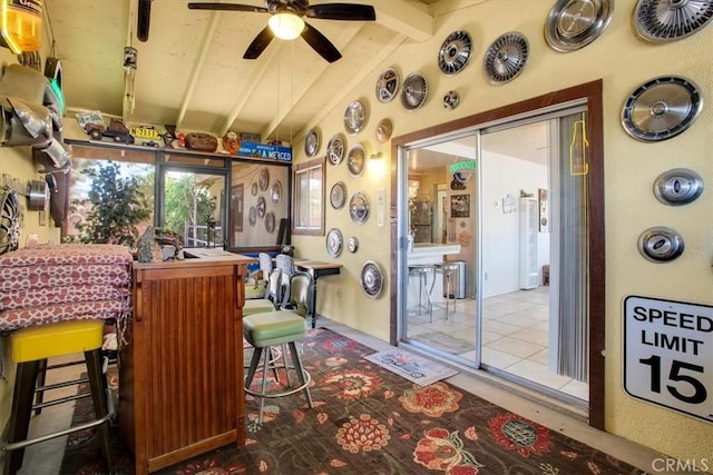 interior space with ceiling fan and vaulted ceiling with beams