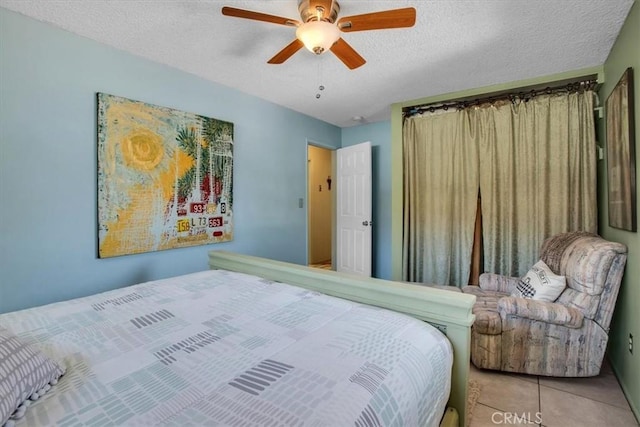 tiled bedroom featuring ceiling fan and a textured ceiling