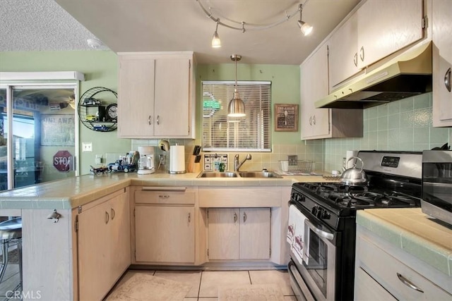 kitchen featuring appliances with stainless steel finishes, decorative light fixtures, sink, decorative backsplash, and kitchen peninsula