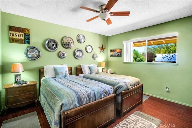 bedroom with ceiling fan, dark hardwood / wood-style floors, and a textured ceiling