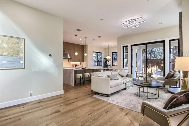 living room featuring sink and light hardwood / wood-style flooring