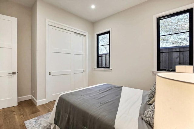 bedroom with light hardwood / wood-style floors and a closet