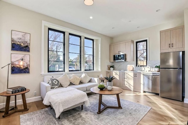 living room with sink and light wood-type flooring