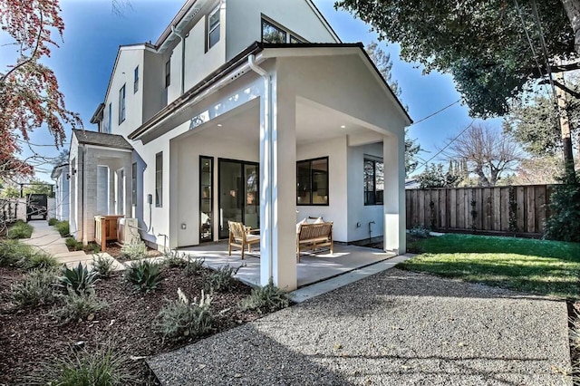 back of house with a yard and a patio