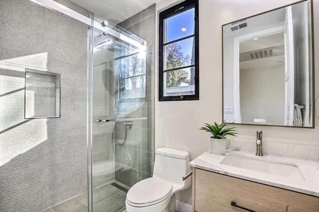 bathroom with vanity, a shower with shower door, and toilet