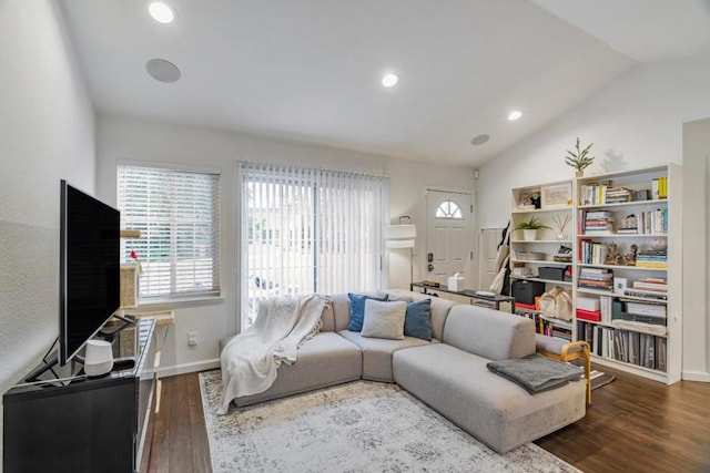 living room featuring lofted ceiling, a healthy amount of sunlight, and dark hardwood / wood-style flooring