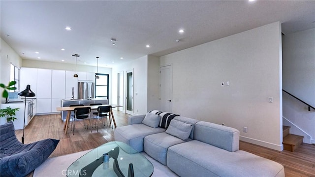 living room featuring sink and light hardwood / wood-style flooring