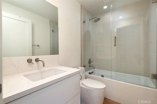 full bathroom featuring vanity, toilet, and combined bath / shower with glass door