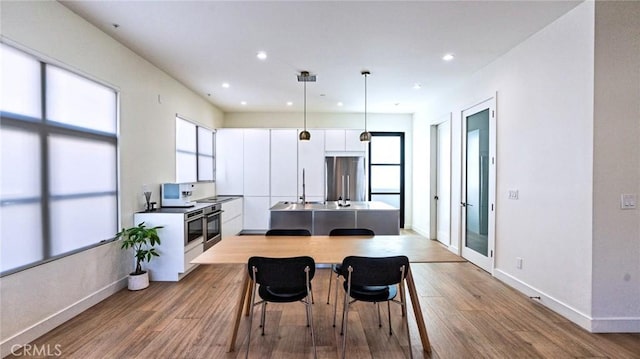 dining area with sink and light hardwood / wood-style flooring