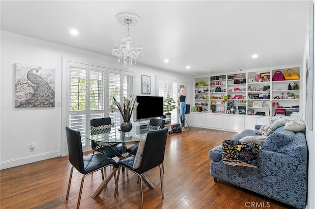 dining room with a notable chandelier, wood-type flooring, and built in features