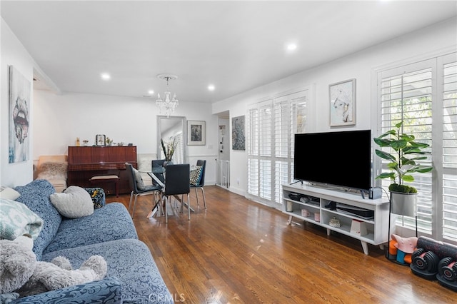 living room with a notable chandelier and dark wood-type flooring