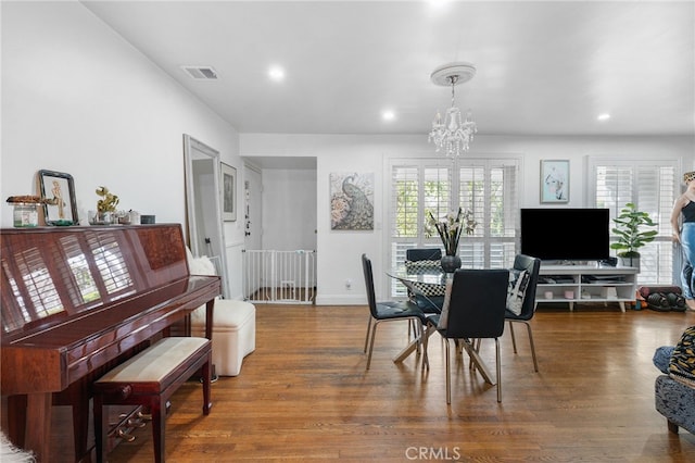 dining area featuring wood-type flooring and a chandelier