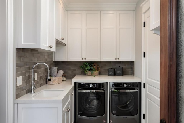 washroom featuring cabinets, sink, and independent washer and dryer