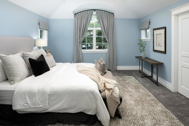 carpeted bedroom with lofted ceiling