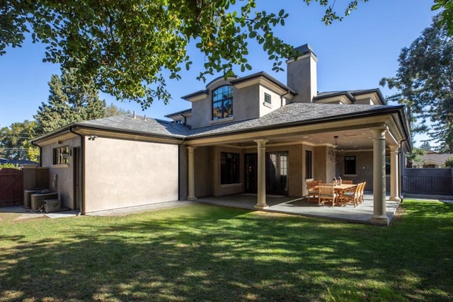 back of house featuring a lawn and a patio