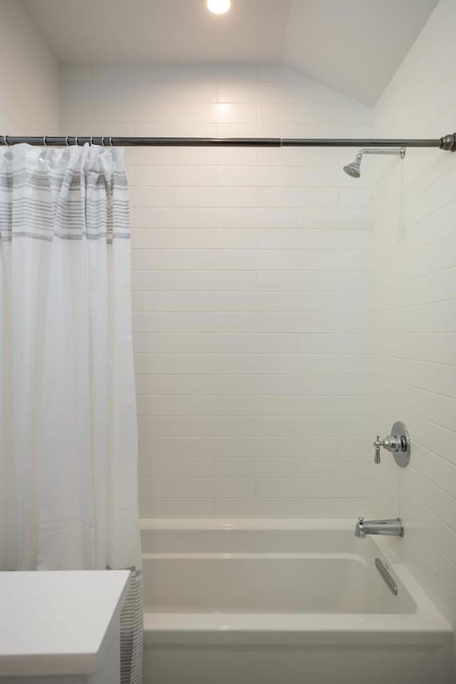 bathroom with shower / bath combination with curtain and vaulted ceiling