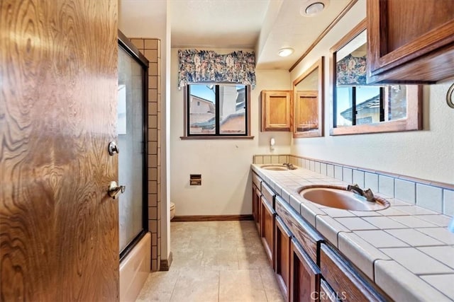 full bathroom featuring vanity, combined bath / shower with glass door, and toilet