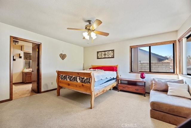 bedroom featuring ceiling fan, ensuite bathroom, and light carpet