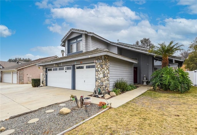 traditional-style house with stone siding, driveway, a front yard, and fence