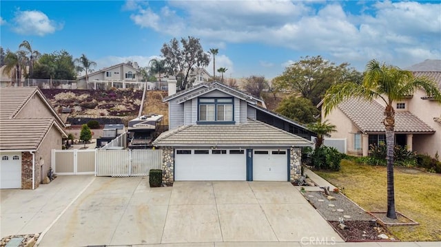 view of front of house with a gate, a front lawn, a garage, stone siding, and a tile roof