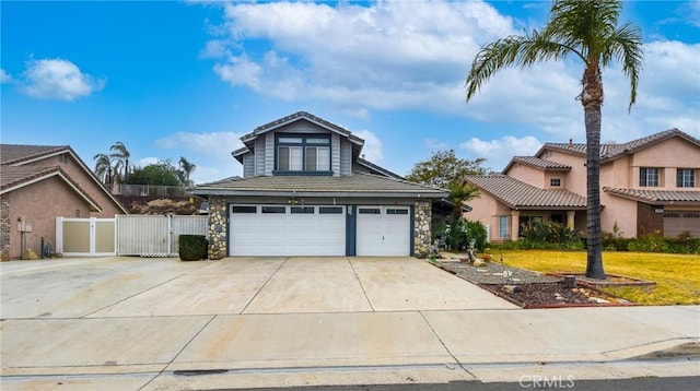 view of front of home featuring a garage, a gate, stone siding, and driveway