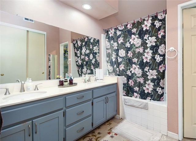 full bathroom with a sink, visible vents, a shower with shower curtain, and double vanity