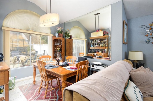 dining area with tile patterned floors, baseboards, and lofted ceiling