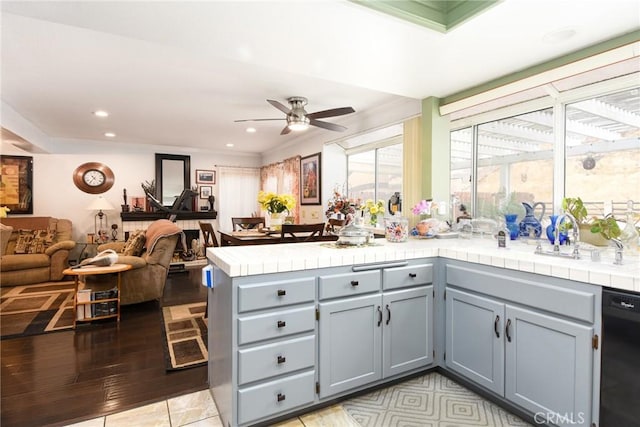 kitchen with a ceiling fan, open floor plan, tile countertops, a peninsula, and dishwasher