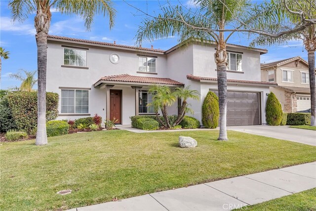 mediterranean / spanish-style house with a garage and a front yard