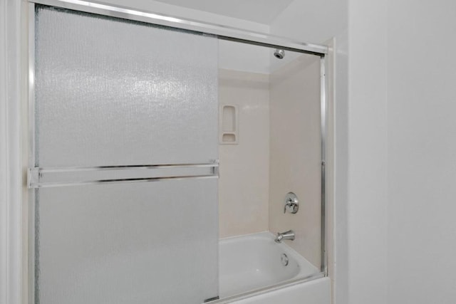 bathroom with bath / shower combo with glass door