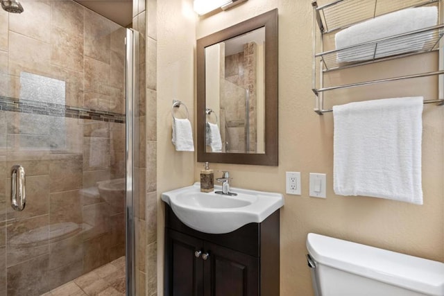 bathroom featuring vanity, an enclosed shower, and toilet