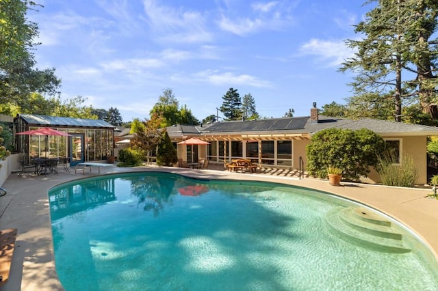 view of pool with a diving board and a patio area