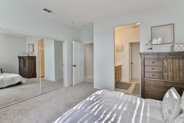 carpeted bedroom featuring ensuite bathroom and a closet