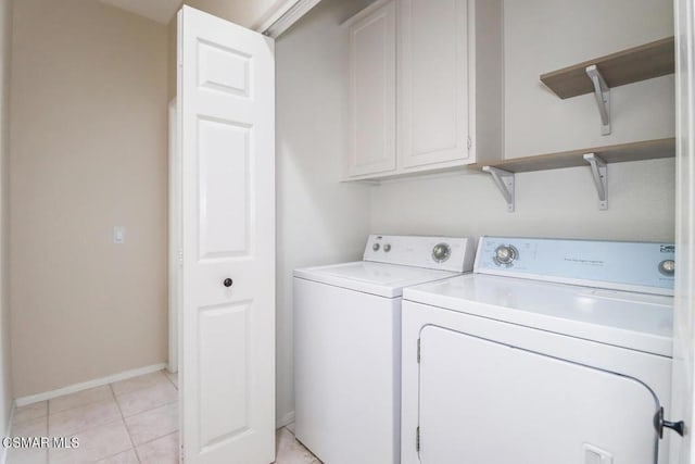 laundry room featuring cabinets, light tile patterned flooring, and washing machine and clothes dryer