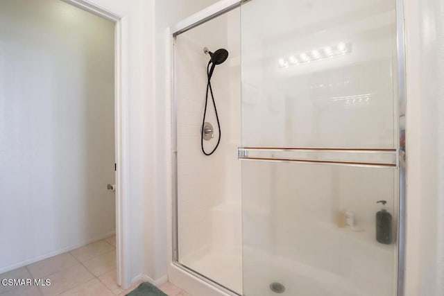 bathroom with an enclosed shower and tile patterned flooring