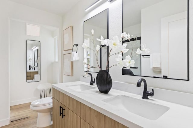 bathroom with hardwood / wood-style flooring, vanity, and toilet