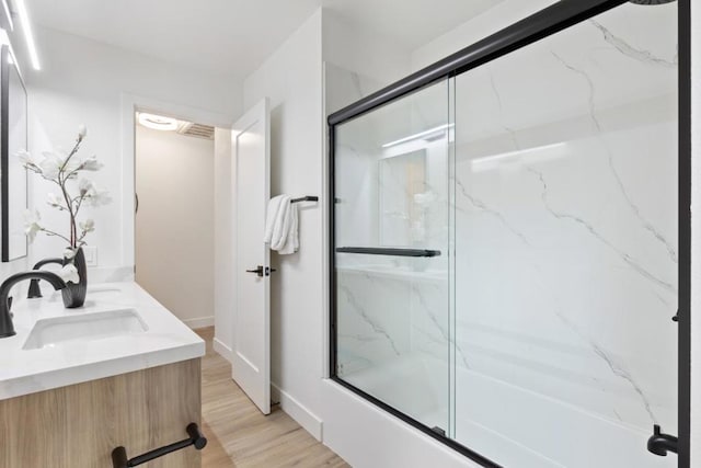 bathroom with enclosed tub / shower combo, vanity, and hardwood / wood-style floors